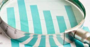 A,Magnifying,Glass,Is,Placed,Over,A,Teal,Bar,Chart,